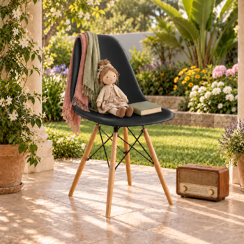 Modern matte black molded plastic Eames style chair with natural wooden legs and black metal wire bracing on a outdoor patio